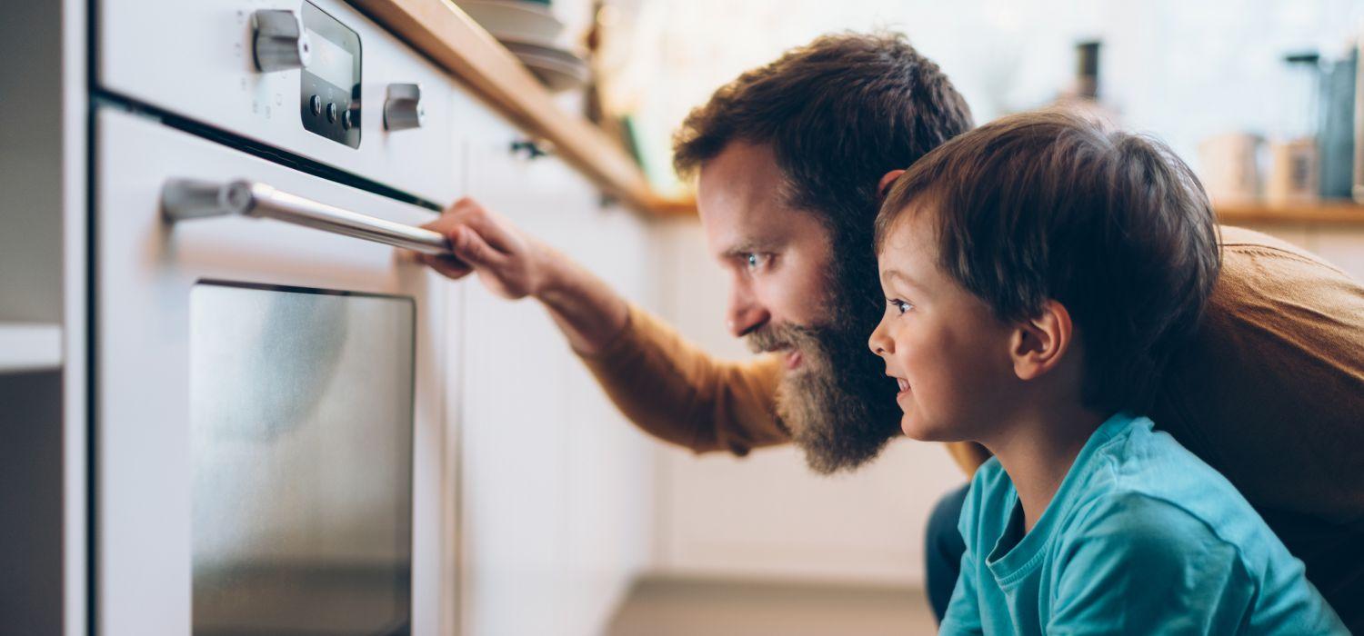 father and son looking at oven