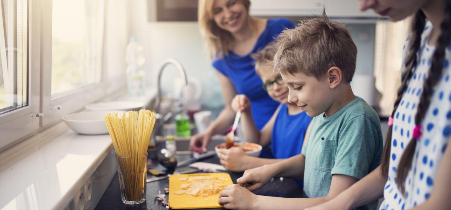 Kids cooking noodles with mum